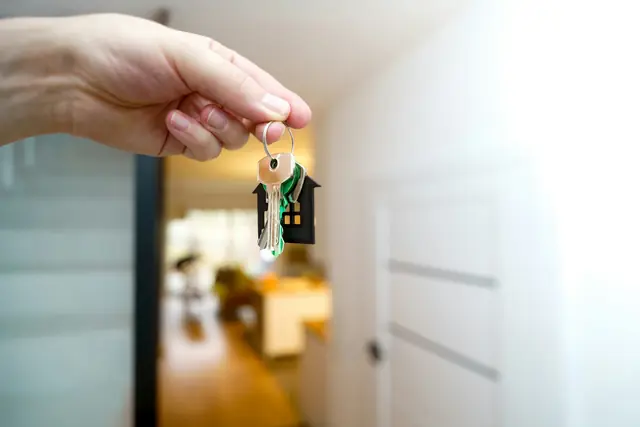 Unas llaves de casa en la mano, en el recibidor de un piso.